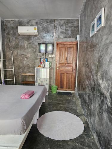 Habitación pequeña con cama y puerta de madera en Horizon Resort, en Ko Samed