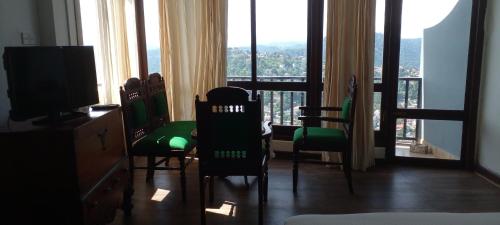 a room with chairs and a desk and a television at Lawan One Kandy in Kandy