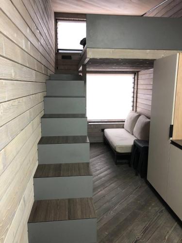 a staircase in a tiny house with a couch at Небокрай in Palyanytsya