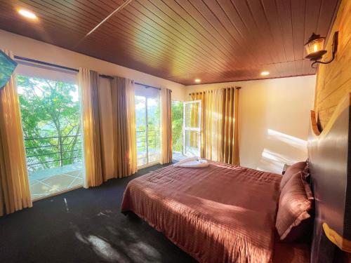a bedroom with a bed and a large window at Che Resort in Digana
