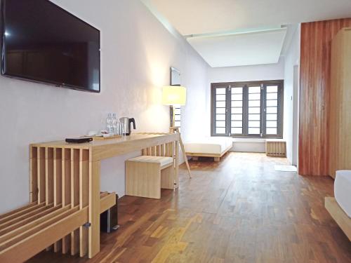 a living room with a desk and a television on a wall at Malino Highlands in Malino