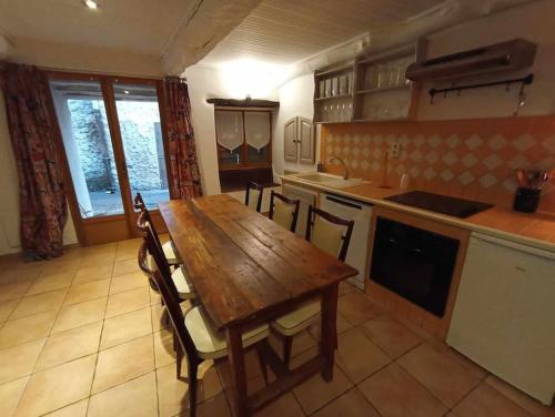 une cuisine avec une table en bois et quelques chaises dans l'établissement Appartement de campagne à Limans, à Limans