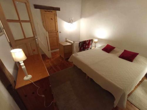 a bedroom with a bed with red pillows on it at Appartement de campagne à Limans in Limans