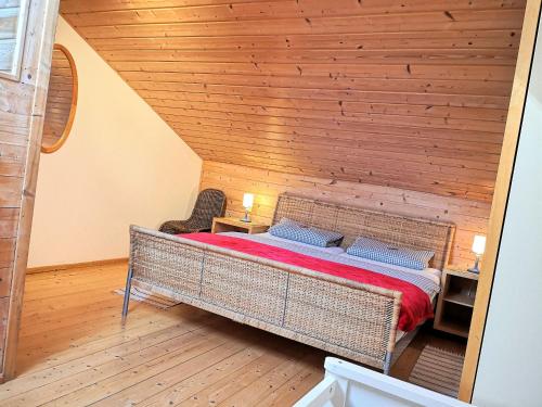 a bed in a room with a wooden wall at Ponyferienhof Eder in Hengersberg