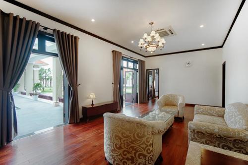 a living room with a table and two chairs at Ban Thach Riverside Hotel & Resort in Tam Kỳ