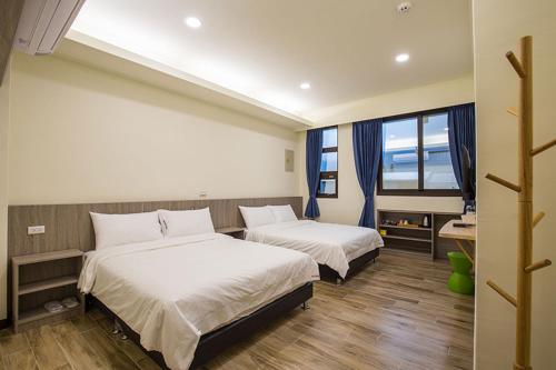 a bedroom with two beds and a window at Blue Sky Hill Homestay 臺東縣民宿1467號 in Guanshan