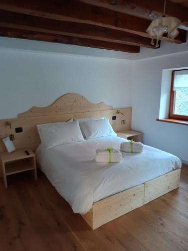 ein Schlafzimmer mit einem Holzbett mit zwei Tabletts drauf in der Unterkunft La Farie in Mediis