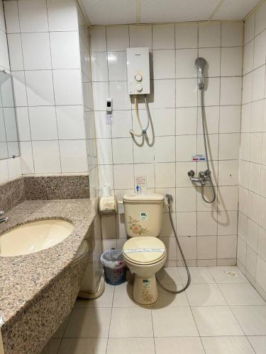 a bathroom with a shower and a toilet and a sink at Chung Hsin Hotel 中信酒店 in Phnom Penh