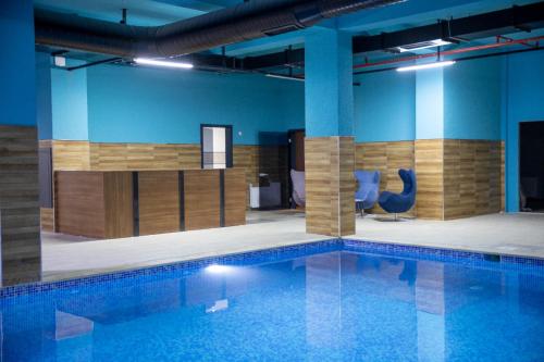 uma piscina com duas cadeiras azuis num edifício em Blue Vista Hotel & SPA em Esenyurt