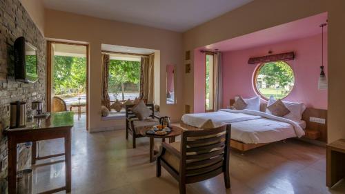 una camera con letto, tavolo e sedie di The Chitvan Resort a Ajmer