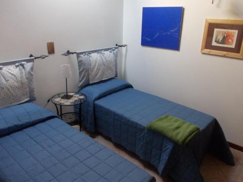 アスコリ・ピチェーノにあるDimora Giosafattiのベッドルーム1室(ベッド2台、ランプ付きテーブル付)
