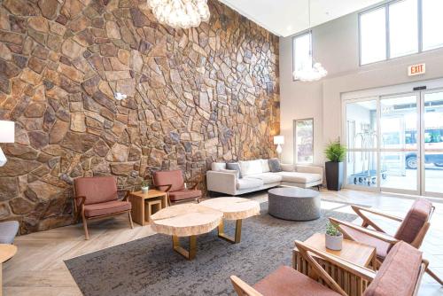a living room with a stone wall at Sandman Hotel Calgary Airport in Calgary