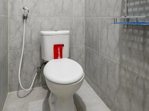 a bathroom with a white toilet with a red box at RedDoorz @ Jemursari Surabaya 2 in Surabaya