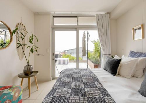1 dormitorio con cama y ventana grande en Plett Holiday Apartment en Plettenberg Bay