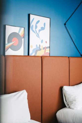 a bedroom with a bed and two pictures on the wall at Ibis Rouen Centre Rive Gauche Mermoz in Rouen