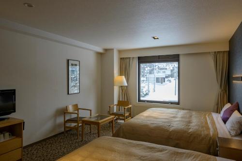 a hotel room with a bed and a window at Hotel Edel Warme in Furano