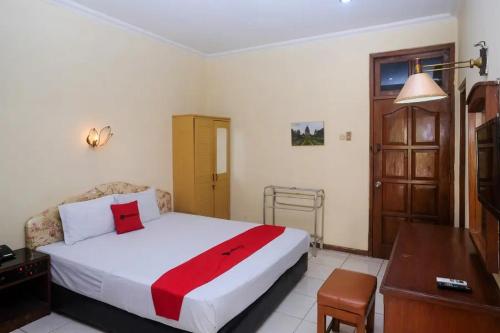 um quarto com uma cama, uma secretária e uma mesa em RedDoorz Plus @ Laweyan em Surakarta