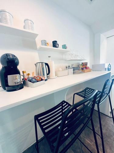 a kitchen with two chairs and a counter with a coffee maker at Ocean Pie Phuket - Adult Only in Rawai Beach