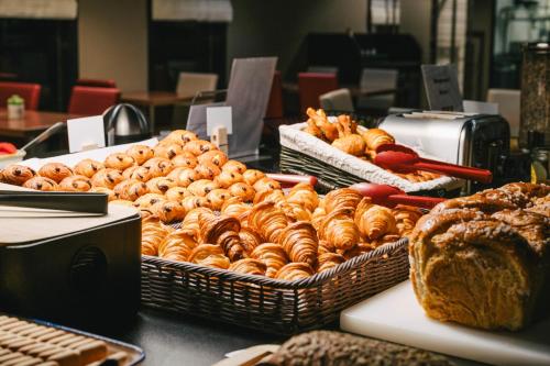 a display of bread and pastries on a table at Ibis Rouen Centre Rive Gauche Mermoz in Rouen