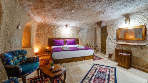ネヴシェヒルにあるLa Vie Cappadocia Suitesの石造りのベッドルーム1室(ベッド1台付)