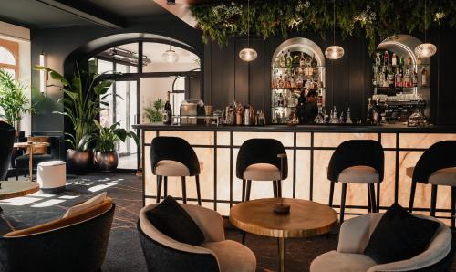 a bar with chairs and a counter in a room at Grand Hôtel Du Parc - Teritoria in Aix-les-Bains