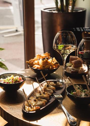 a table with plates of food and glasses of wine at Grand Hôtel Du Parc - Teritoria in Aix-les-Bains