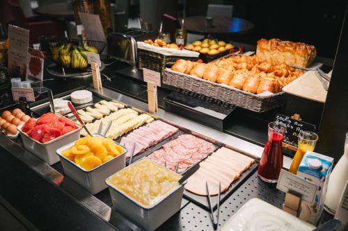 a buffet with many different types of food on display at Ibis Rouen Centre Rive Gauche Mermoz in Rouen
