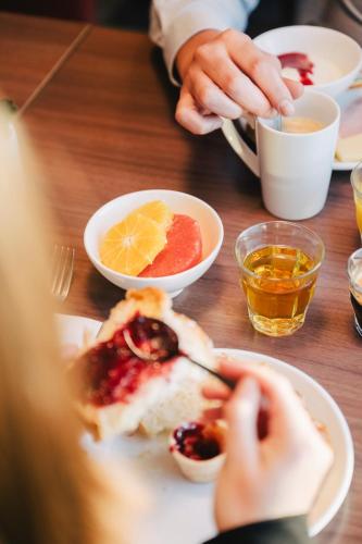 a person eating food on a table with plates of food at Ibis Rouen Centre Rive Gauche Mermoz in Rouen
