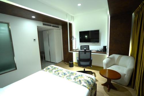 a hotel room with a bed and a chair and a table at Grand River View Hotel - Rajshahi in Rājshāhi