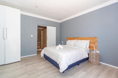 a bedroom with a large bed with blue walls at Bloubergstrandlodge in Bloubergstrand