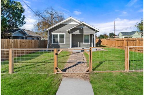 a fence in front of a small house at Step into Comfort in this 3BR2BA Downtown Retreat in San Antonio