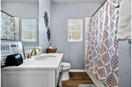 a bathroom with a sink and a toilet at Step into Comfort in this 3BR2BA Downtown Retreat in San Antonio