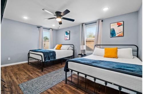 a bedroom with two beds and a ceiling fan at Step into Comfort in this 3BR2BA Downtown Retreat in San Antonio