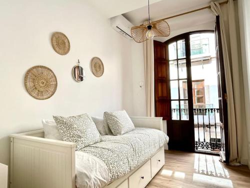 een witte kamer met een bed met kussens erop bij Hispalis Columnas de la Alameda in Sevilla