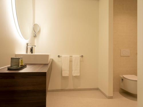a bathroom with a sink and a toilet at DoubleTree by Hilton Sittard in Sittard