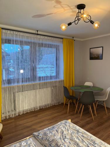 a living room with a table and a window at Dwunastka in Zakopane