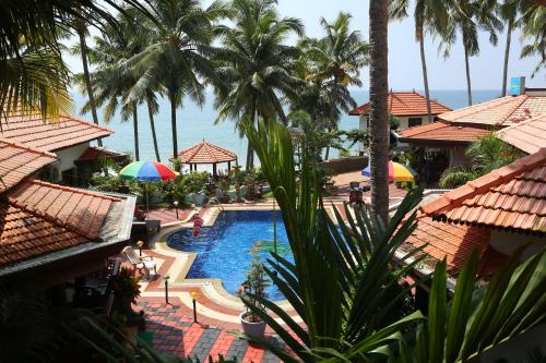 a view of the pool at a resort with palm trees at Samsara Harmony Beach Resort in Varkala