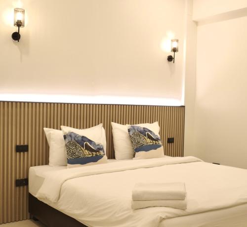 a bedroom with a large bed with blue and gold pillows at Now Hostel in Ban Chang