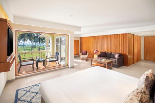 a hotel room with a bed and a living room at Taj Exotica Resort & Spa, Goa in Benaulim