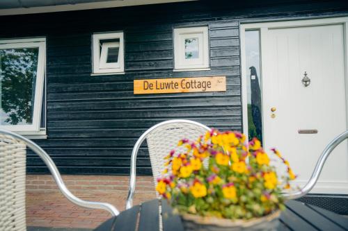 un cesto di fiori seduto su un tavolo di fronte a una casa di B&B de Luwte Cottage a Zwolle
