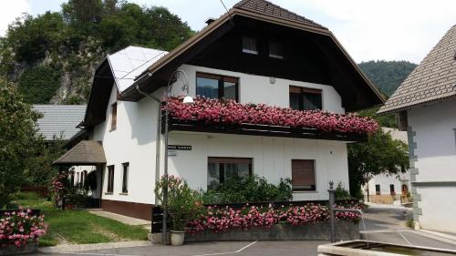 a white house with pink flowers on it at Apartments Gregorc in Bled