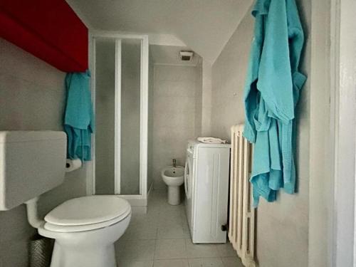 een badkamer met een toilet en een wastafel met blauwe handdoeken bij Centralissimo appartamento su due livelli "2" in Turijn