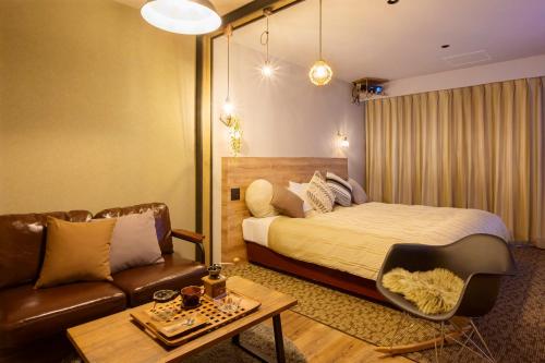 um quarto de hotel com uma cama e um sofá em Hotel Edel Warme em Furano