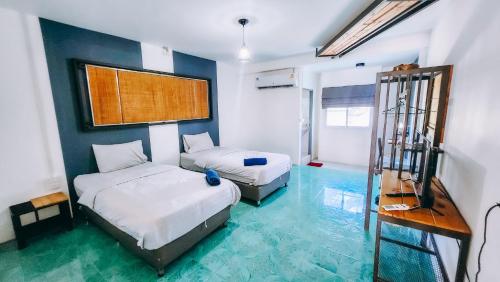 Downtown Kohlarn Resort في كو لان: غرفة نوم بسريرين وارضية زرقاء