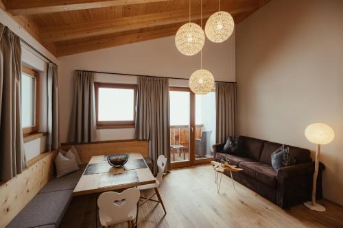 a living room with a couch and a table at Villa Flora Mountain Lodges in San Cassiano