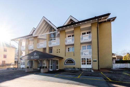 an apartment building with a parking lot in front of it at Hotel garni Meledrio in Dimaro