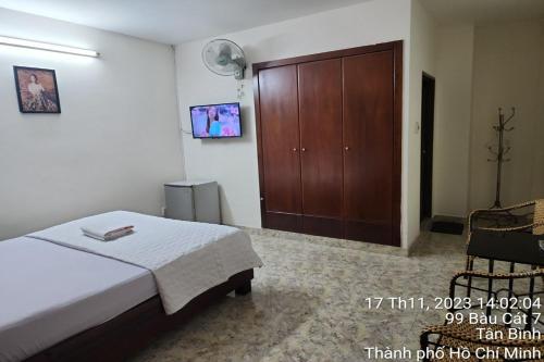 een slaapkamer met een bed en een houten kast bij BAU CAT HOTEL in Ho Chi Minh-stad