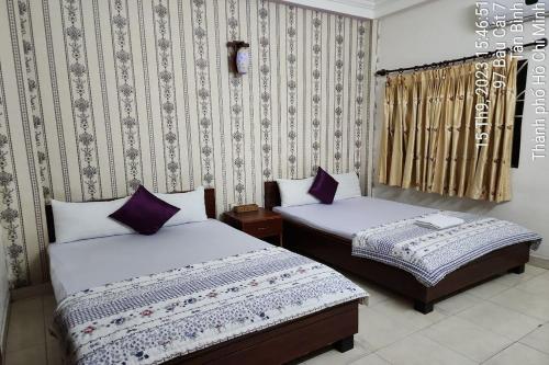 - une chambre avec 2 lits et du papier peint dans l'établissement BAU CAT HOTEL, à Hô-Chi-Minh-Ville