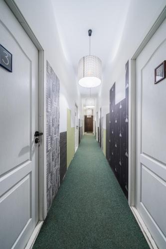 a hallway with a green carpet and a door at Halės Self Check-in Guest House - Lollo Stay in Vilnius
