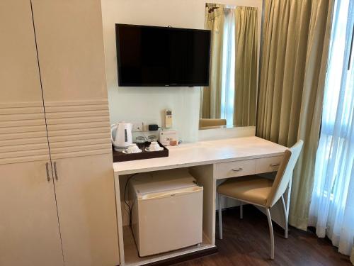 a hotel room with a desk with a tv on it at Calypzo Bangkok in Bangkok